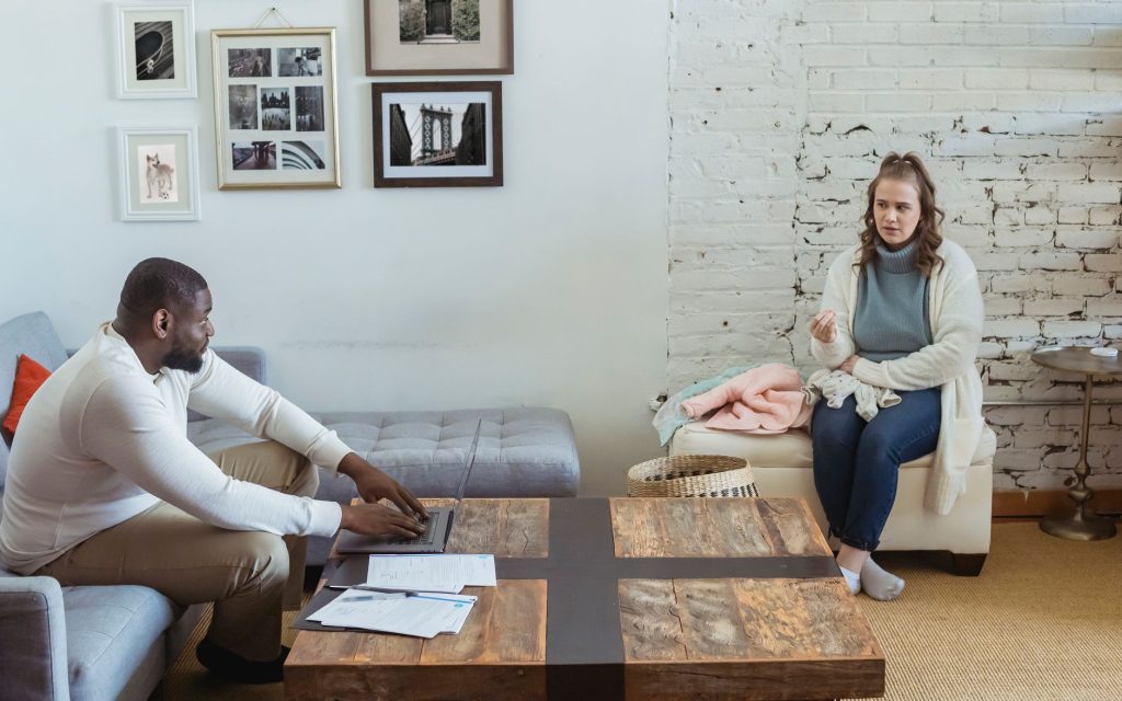a519a769 9e0a 407c 98ef f4417bf4330f Full body of multiracial couple sitting in living room and sorting things out