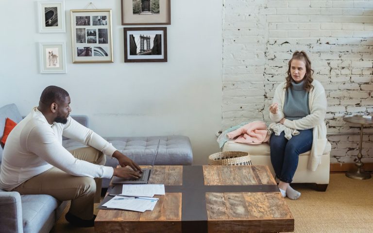 a519a769 9e0a 407c 98ef f4417bf4330f Full body of multiracial couple sitting in living room and sorting things out