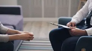 f6b64e83 6dc5 4f9a b938 09d4363f6290 A therapy session with a psychologist and patient, discussing mental health indoors.