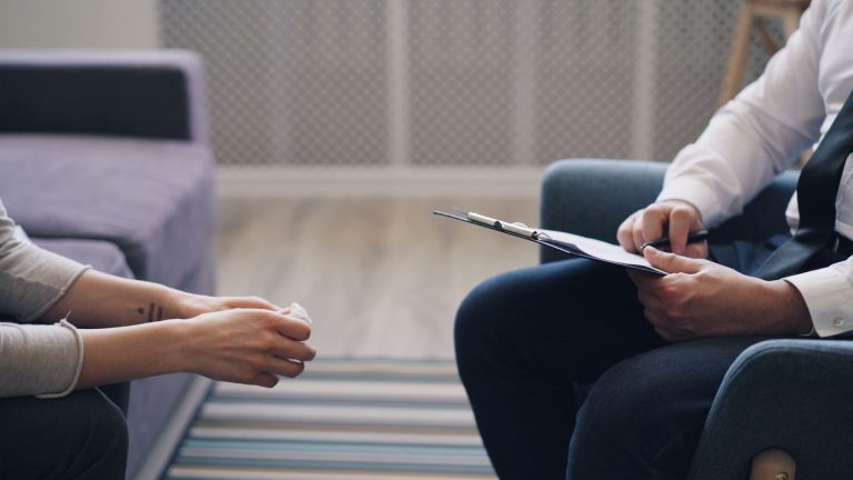 f6b64e83 6dc5 4f9a b938 09d4363f6290 A therapy session with a psychologist and patient, discussing mental health indoors.