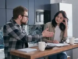 A couple engaging in a serious conversation in their kitchen, showcasing relationship dynamics.